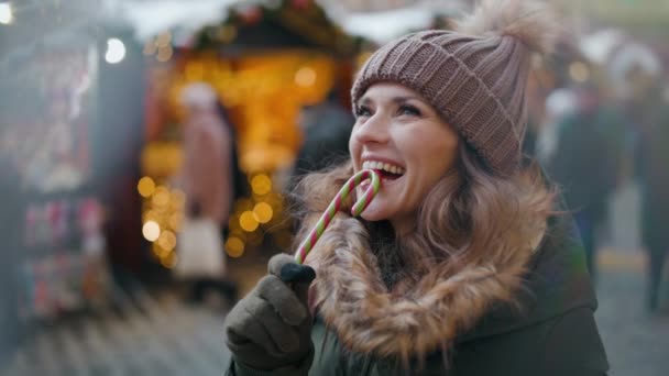 Kış Fuarında Yeşil Ceketli Kahverengi Şapkalı Gülümseyen Modern Kadın — Stok video