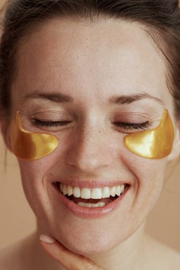 Bej arka planda göz bantları olan mutlu modern kadın..