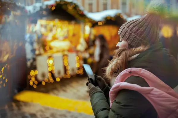 Gezien Van Achteren Vrouw Kerstmarkt Stad Met Behulp Van Smartphone — Stockfoto