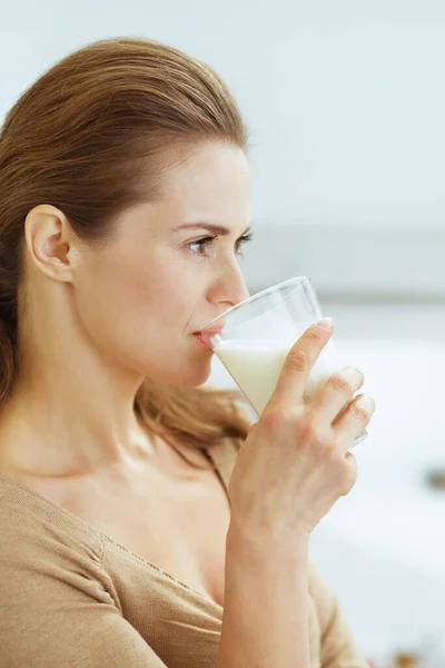 Young woman drinking milk in modern kitchen