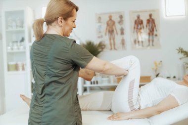 Sağlık hizmeti zamanı. Gülümseyen kadın masaj terapisti müşteriyle birlikte masaj odasında..