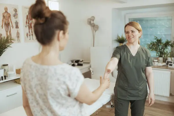 Gesundheitszeit Lächelnde Massagetherapeutin Frau Massagekabinett Mit Klient Beim Händeschütteln — Stockfoto