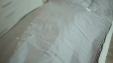 Sağlık hizmeti zamanı. Rahatlamış modern kadın masaj dolabında termal battaniyeyle viski kundaklama işlemi yapıyor..