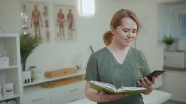 Gesundheitszeit Besorgte Medizinische Masseurin Massageschrank Mit Notizbuch Smartphone Gespräch — Stockvideo
