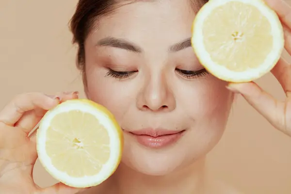 modern woman with lemon against beige background.