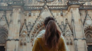 Prag 'da, Çek Cumhuriyeti' nde sarı bluz ve yağmurluklu bir kadının cazibesini keşfederken görüldü..