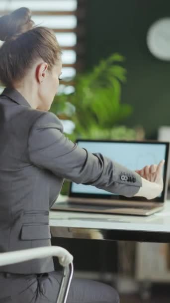 持続可能な職場 現代の緑のオフィスストレッチ手でグレーのビジネススーツで現代のビジネス女性の後ろから見た — ストック動画
