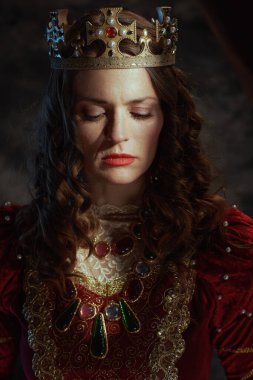 Koyu gri arka planda taçlı kırmızı elbiseli ortaçağ kraliçesi..