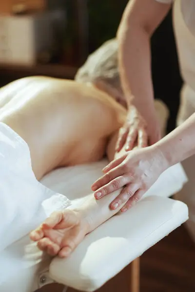 Healthcare time. Closeup on massage therapist in spa salon massaging clients arm on massage table.