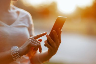 Yaz zamanı. Akıllı telefon uygulaması kullanan bir kadına yakın çekim.