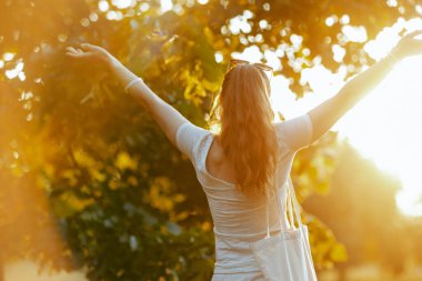 Yaz zamanı. Şehir parkında beyaz gömlekli mutlu orta yaşlı kadın..