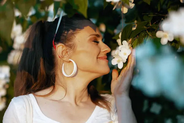 夏天的时候幸福优雅的女性 身穿白衬衫 靠近开花的树 — 图库照片