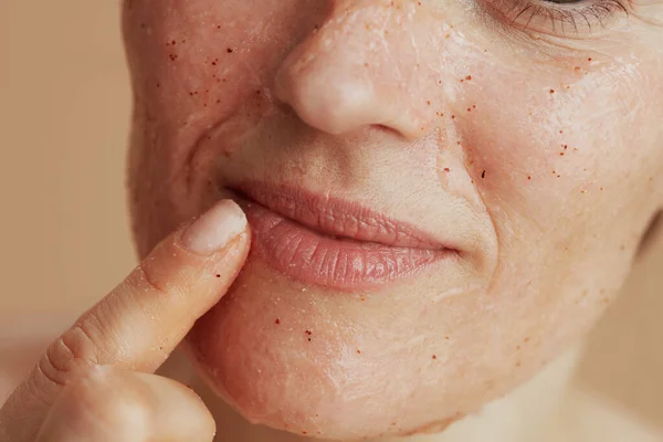 Closeup on young woman with face scrub.