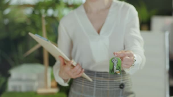 移動する時間です 幸せな現代中年の女性のリアクター クリップボードおよびキーが付いている白いブラウスの現代緑のオフィス — ストック動画