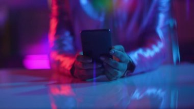 Neon metaevren fütüristik konsepti. Ofiste akıllı telefon uygulaması kullanan iş kadınına yakın çekim.