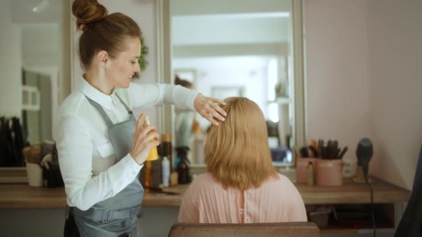 现代美容院的女性美发师 拥有一瓶护发品和客户 — 图库视频影像