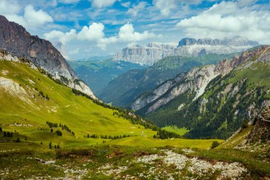 Dolomitlerde yaz zamanı. Dağlı, tepeli, bulutlu ve ağaçlı manzara.