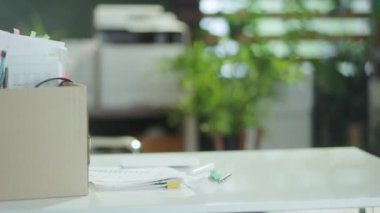 Yeni bir iş. Modern yeşil ofiste masa ve karton kutuda kişisel eşyalar..