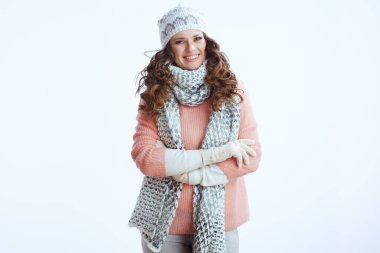 Merhaba kış. Süveter, eldiven, şapka ve atkı giymiş, beyaz arka planda gülümseyen şık bir kadının portresi..