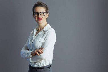 40 yaşında, beyaz bluzlu, gri gözlüklü mutlu bir kadın..