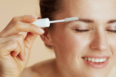 Gülümseyen modern kadın kaş fırçasıyla.