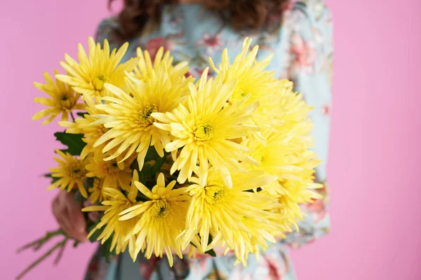 中年妇女用黄色菊花和粉红色背景的花朵进行包扎 — 图库照片