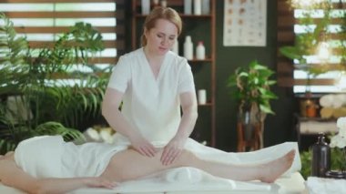 Sağlık hizmeti zamanı. Spa salonunda masaj terapisti müşterilere bacak masajı yapıyor..