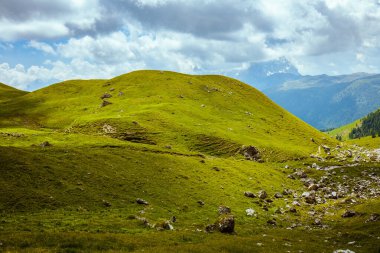Dolomitlerde yaz zamanı. Tepeli, bulutlu ve kayalıklı manzara.