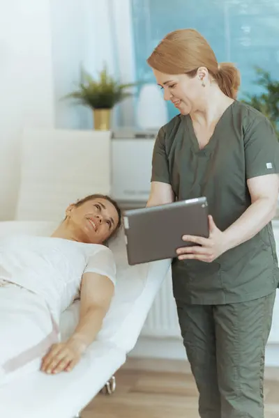 Gesundheitszeit Glückliche Massagetherapeutin Massageschrank Mit Klient Und Tablet — Stockfoto