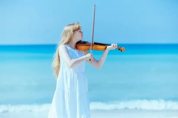 遊ぶバイオリンと海岸の軽いドレスで現代のティーンエイジャーガール — ストック写真