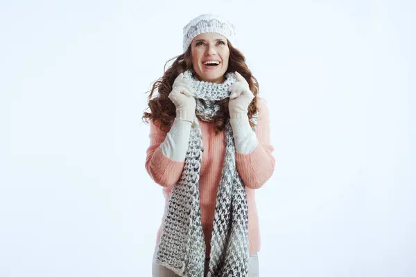 Hello winter. smiling modern middle aged woman in sweater, mittens, hat and scarf against white background looking up on copy space.