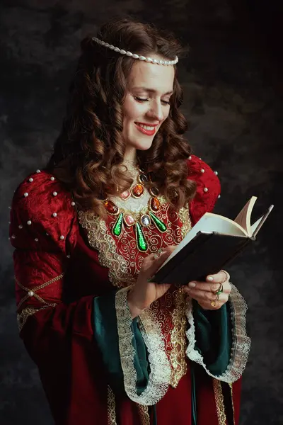 Sorridente Regina Medievale Abito Rosso Con Libro Sfondo Grigio Scuro — Foto Stock