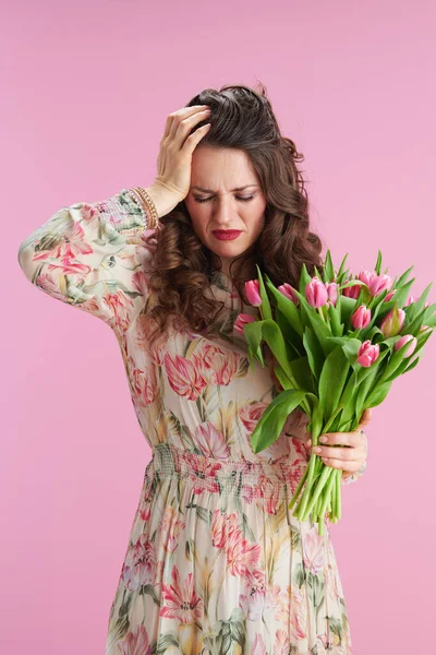 浓重的现代女性 有着长长的波浪般的黑发 郁金香花束 背景粉色 — 图库照片