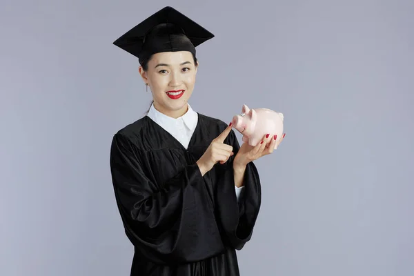 Smiling Young Female Asian Graduate Student Piggy Bank Isolated Grey — Stock Photo, Image