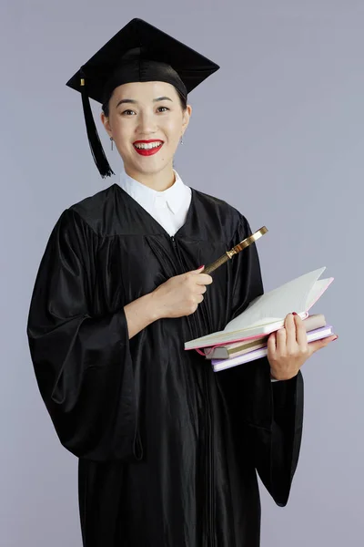 幸せな現代女性アジアの大学院生本 ノートブック グレーの背景に対する壮大なガラス — ストック写真