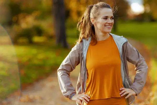 Hello autumn. happy stylish woman in fitness clothes in the park relaxing after workout.