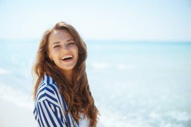 Okyanus kıyısındaki mutlu zarif kadın eğleniyor..