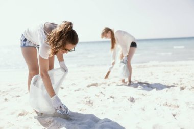 Okyanus kıyısındaki çöp torbalarıyla ilgili çevre aktivistleri..