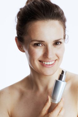 Beyaz arka planda kozmetik krem kavanozu olan mutlu orta yaşlı kadın..