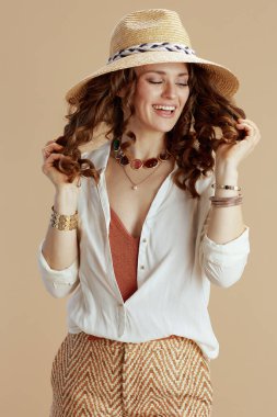 Plaj tatili Beyaz bluz ve şortlu, bej renkli saman şapkalı zarif bir kadın..