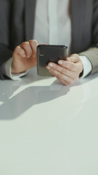 持続可能な職場 スマートフォンアプリを使用してラップトップとグリーンオフィスのグレービジネスススーツの会計士女性のクローズアップ — ストック動画