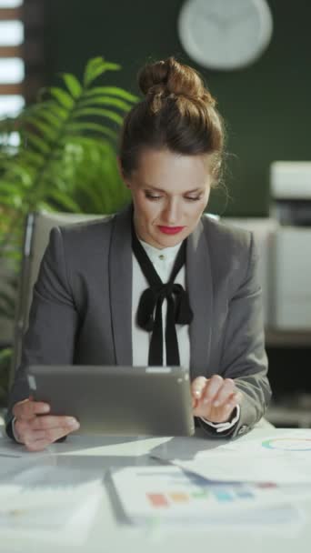 持続可能な職場 タブレットPcを使用したモダンなグリーンオフィスのグレービジネスススーツで現代の女性労働者の笑顔の肖像 — ストック動画