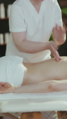 Sağlık hizmeti zamanı. Spa salonundaki masaj terapisti masaj masasında masaj terapisi yapıyor..