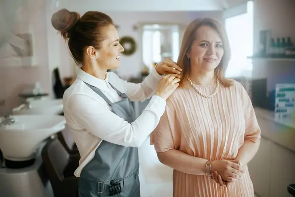 woman hair salon worker in modern beauty studio with client.