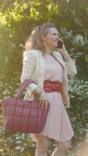 Feliz Mulher Meia Idade Vestido Rosa Jaqueta Branca Cidade Falando — Vídeo de Stock