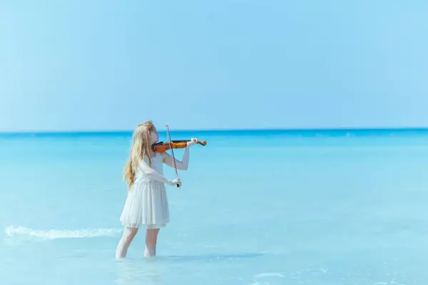 遊ぶバイオリンと海岸の白いドレスで現代の女の子 — ストック写真