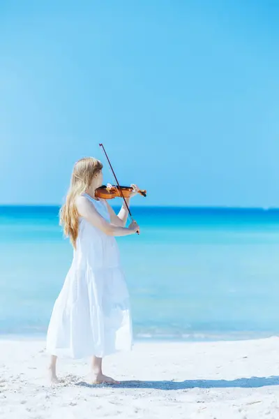 海岸で遊ぶバイオリンと白いドレスで現代の十代の少女の完全な長さの肖像画 — ストック写真