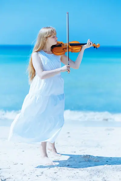海岸で遊ぶバイオリンと白いドレスで現代の若い女性の完全な長さの肖像画 — ストック写真