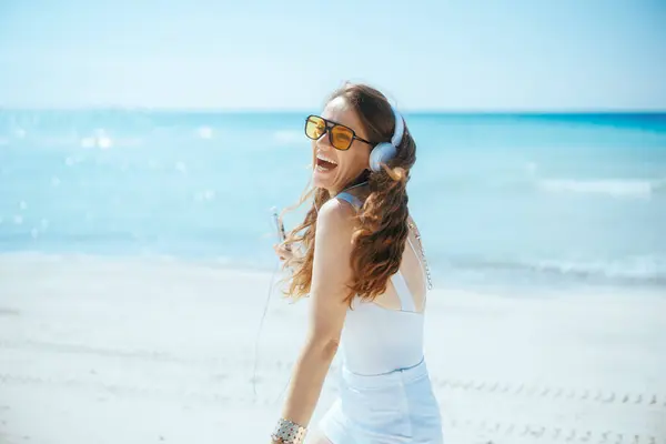 Χαρούμενη Κομψή Γυναίκα Στην Παραλία Ακουστικά Και Χορό Smartphone — Φωτογραφία Αρχείου