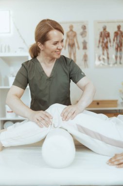 Sağlık hizmeti zamanı. Gülümseyen kadın masaj terapisti müşteriyle birlikte masaj odasında check-up yapıyor..